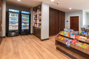 Un área de venta con dos máquinas expendedoras refrigeradas y una exposición de snacks.