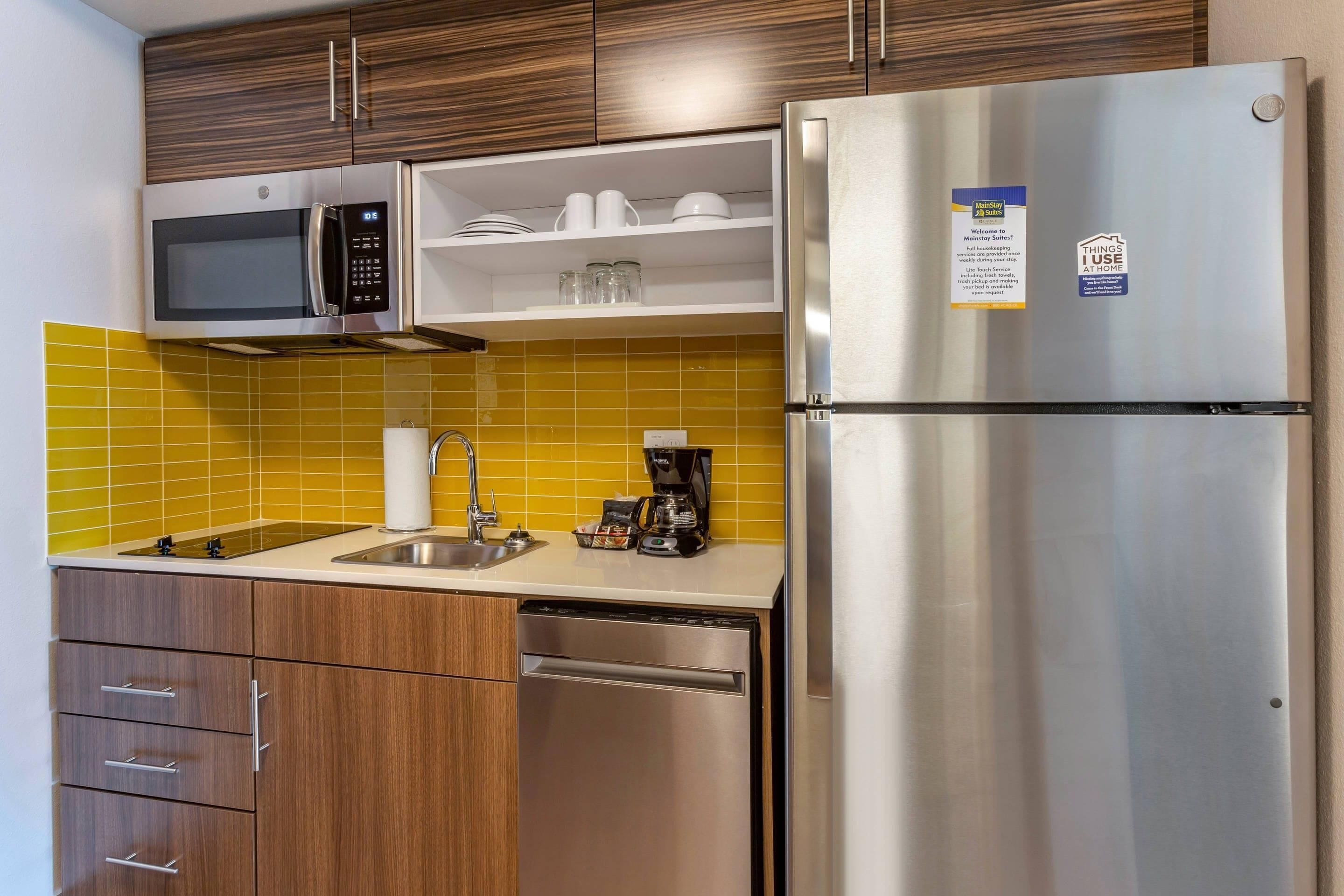 Una cocina compacta con microondas, cafetera y refrigerador.