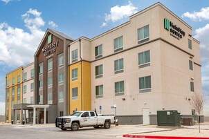Edificio de hotel MainStay Suites con diseño moderno, varios pisos y un área de estacionamiento con una camioneta pickup blanca.