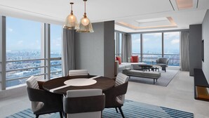 A modern hotel room with a large city view, a round dining table, and a cozy seating area. - Sheraton Guangzhou Panyu (Guangzhou)