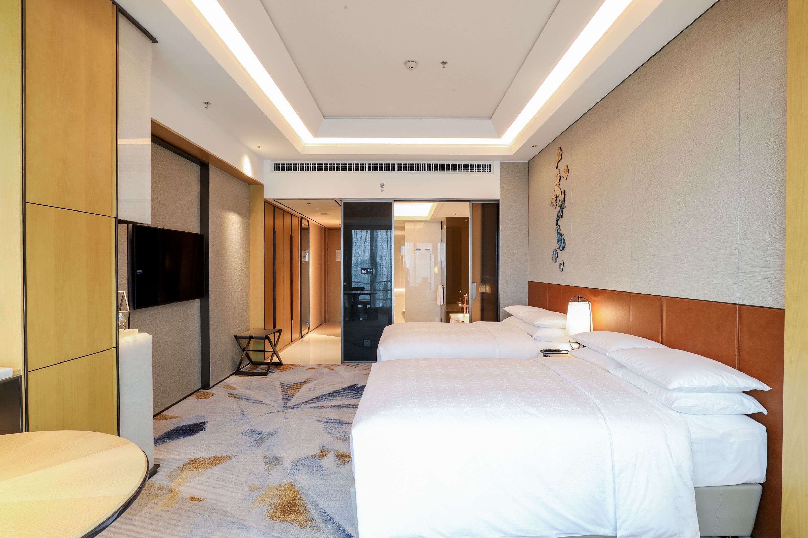 A hotel room with a large bed, a desk, and a television.