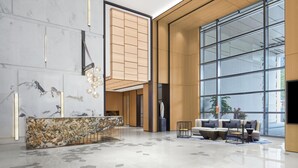 A modern lobby with a marble reception desk, seating area, large windows, and a minimalist design. - Sheraton Guangzhou Panyu (Guangzhou)