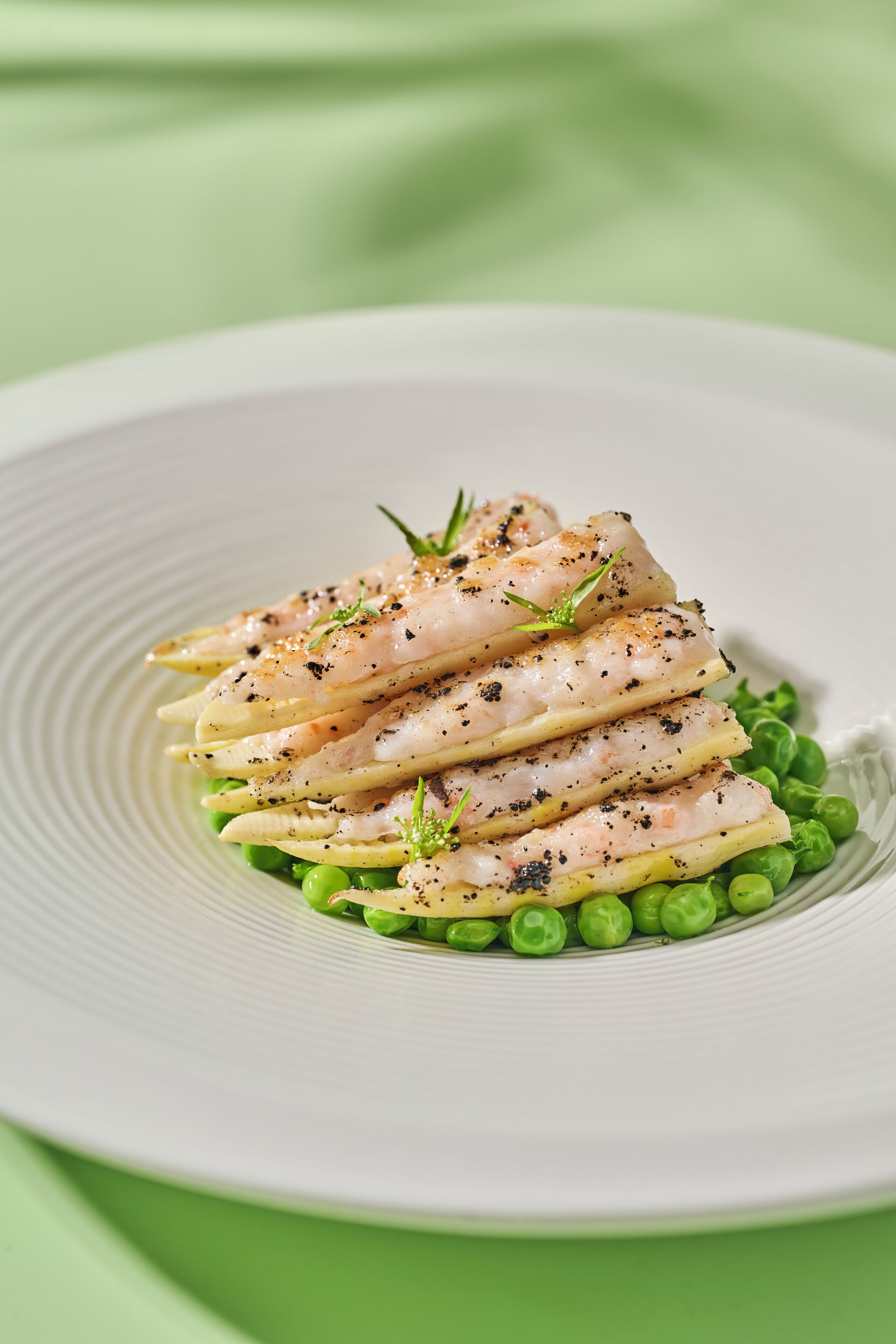 A plate of fish fillets with herbs and peas.