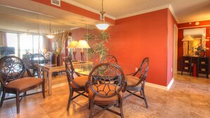 A dining area with a round table, four chairs, and two lamps.
