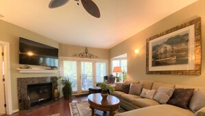 A living room with a fireplace, a sofa, a coffee table, and a television. - Beautiful Furnishings! Great Location! (Myrtle Beach)