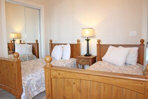 A hotel room with two wooden beds, each with a headboard and footboard, and a nightstand with a lamp between them. - Just an 8 Minute Drive to the Beach.... (Myrtle Beach)