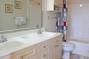 A bathroom with two sinks, a mirror, a toilet, and a shower curtain. - Just an 8 Minute Drive to the Beach.... (Myrtle Beach)