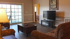 A living room with a TV, a lamp, and patterned furniture. - Just an 8 Minute Drive to the Beach.... (Myrtle Beach)