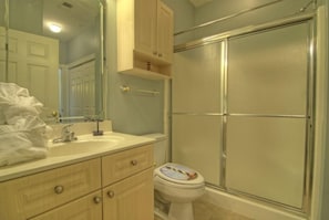 A bathroom with a sink, mirror, cabinet, toilet, and a glass-enclosed shower. - Just an 8 Minute Drive to Myrtle Beach Sands... (Myrtle Beach)