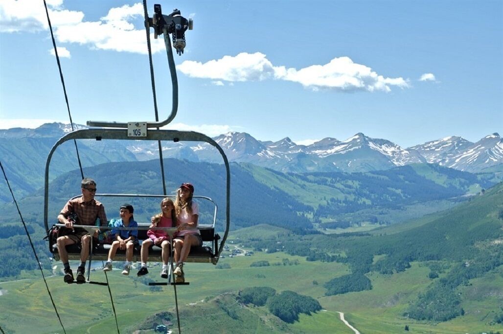 A cable car with passengers enjoying a scenic mountain view.