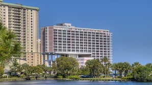 A high-rise hotel with multiple floors, a central courtyard, and a body of water reflecting the buildings. - Comfortable/spacious Villa at Kingston Plantation (Myrtle Beach)