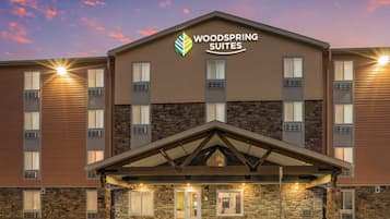 A hotel with a stone facade, multiple windows, and a covered entrance.