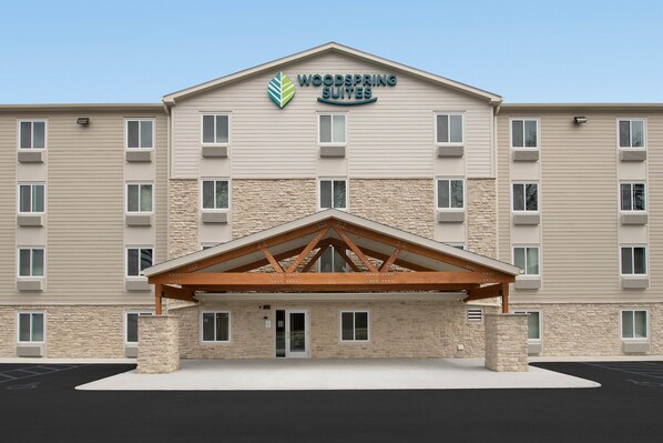 A multi-story hotel with a stone facade and a wooden entrance canopy.