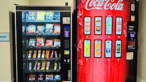 Two vending machines, one with snacks and the other with beverages including Coca-Cola. - WoodSpring Suites Novi Farmington (Northville)