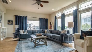 A spacious living room with a sectional sofa, a coffee table, and a ceiling fan. - Five Minute Walk to the Beach Sleeps 11 (Cape Charles)