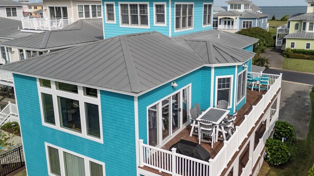 A turquoise house with a balcony, a covered patio, and a view of the ocean. - Five Minute Walk to the Beach Sleeps 11 (Cape Charles)
