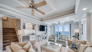 A spacious living room with a fireplace, comfortable seating, and a large TV.