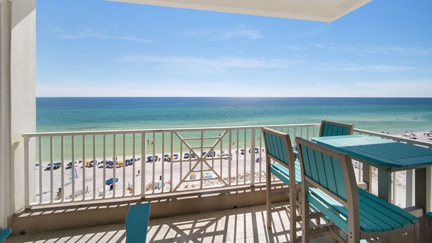 A balcony with a view of a beach and ocean.