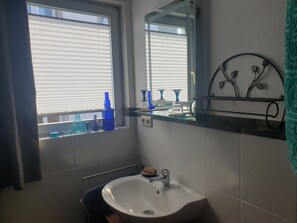 Regadera, secadora de cabello, toallas, papel de baño 