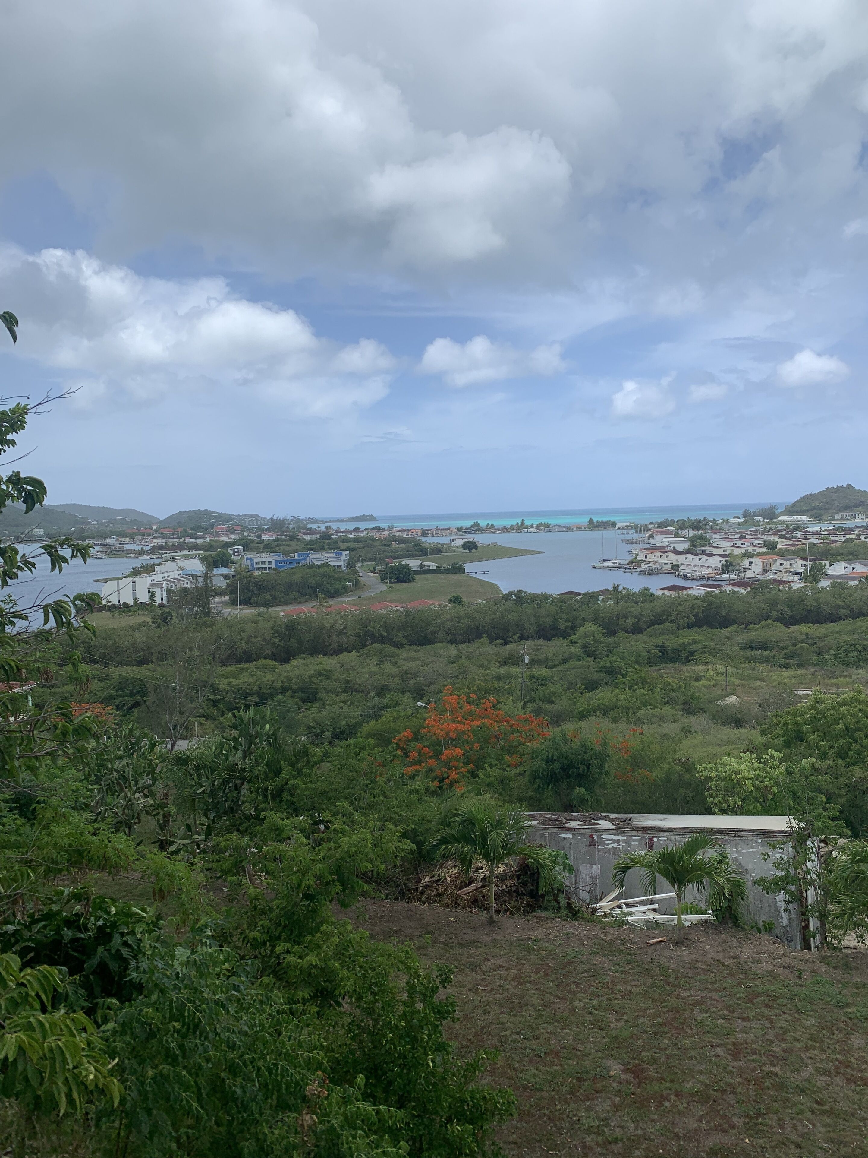 Un paysage côtier offrant une vue sur la mer, avec un petit village et une végétation luxuriante.