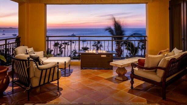 A balcony with a view of the ocean at sunset, furnished with chairs and a table. - Hacienda Beach Club - 3 bedrooms, 8 people. Can also rent as 2 bedrooms (Cabo San Lucas,)