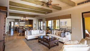 A spacious living room with a large sectional sofa, a coffee table, and a ceiling fan. - Hacienda Beach Club - 3 bedrooms, 8 people. Can also rent as 2 bedrooms (Cabo San Lucas,)