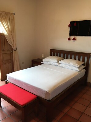 Bedroom with full bed, to the left are French door leading to a private balcony