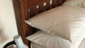 Ein hölzerner Kopfseitenverkleidung mit zwei Kissen und einer Schreibtischlampe.