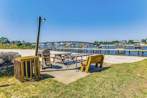 Enjoy a serene waterfront setting with a bridge view, picnic tables, and benches for relaxation and dining.