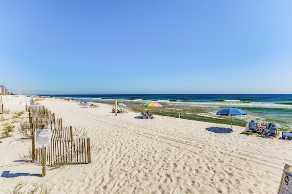 Relax by the ocean with a beach area, complete with umbrellas and comfortable seating.