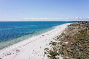 A beach with clear blue water, white sand, and sparse vegetation. - Azure—Beachside Resort Escape for Groups (Marybrook)
