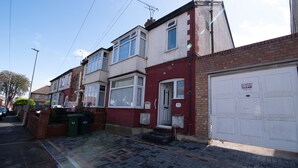 A residential street with terraced houses, a clear driveway, and a garage door with a 'No Parking' sign. - Newark House - 2 Bedroom Apartment (Maidenhall)