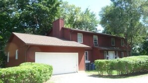A two-story house with a garage, surrounded by greenery and trees. - Awesome house in Waterhill Neighborhood (Ann Arbor)