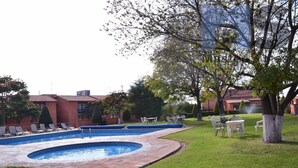 A swimming pool with lounge chairs and a grassy area. - +MS +Espectacular Suite +Alberca Áreas Verdes +9A (Santiago de Querétaro)