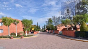 A residential street with brick houses, potted plants, and a clear sky. - +MS +Espectacular Suite +Alberca Áreas Verdes +9A (Santiago de Querétaro)