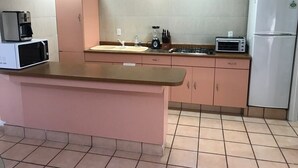 A kitchen with a pink countertop, a microwave, a toaster, and a refrigerator. - +MS +Suite Perfecta +Centro +Av Zaragoza +S5 (Santiago de Querétaro)