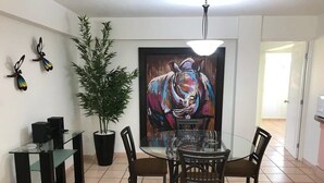 A dining area with a round glass table, four chairs, a potted plant, and a painting on the wall. - +MS +Suite Perfecta +Centro +Av Zaragoza +S5 (Santiago de Querétaro)