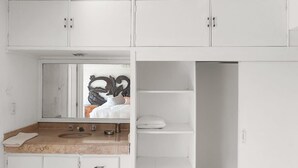 Une salle de bain avec un lavabo, un miroir et des meubles blancs.