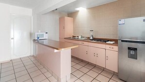 Une cuisine compacte équipée d’un four à micro-ondes, d’une cuisinière et d’un réfrigérateur.