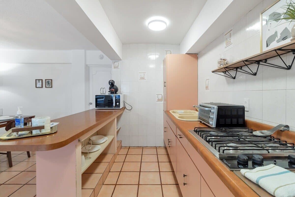 A modern kitchen with a central island, a microwave, a toaster, and a gas stove.