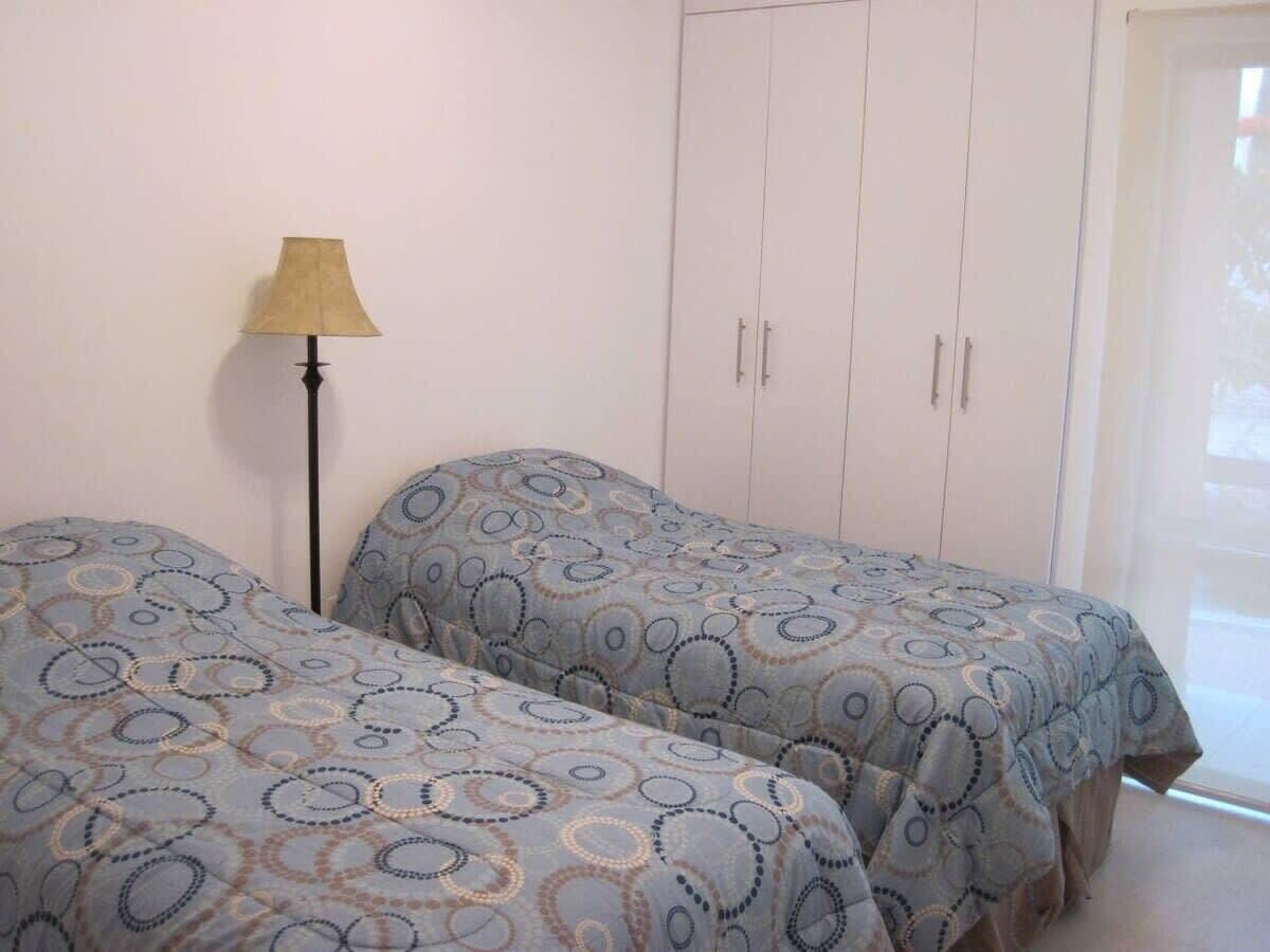 Een slaapkamer met twee bedden, een lamp en een kledingkast.