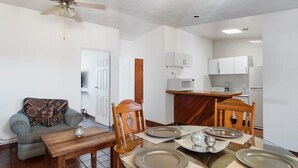 Un comedor con una mesa de madera, sillas y un ventilador de techo.