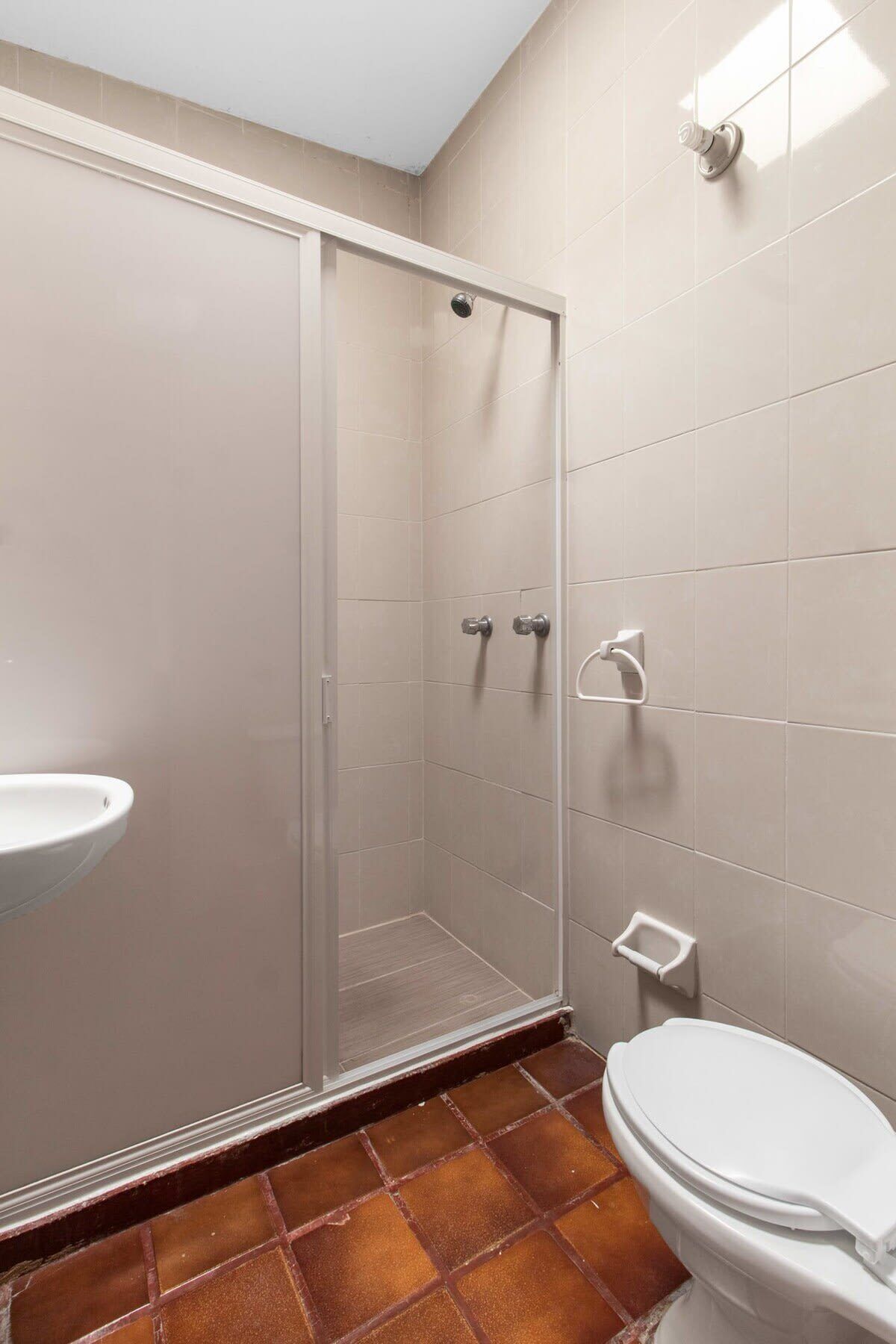 A bathroom with a shower, toilet, and sink.