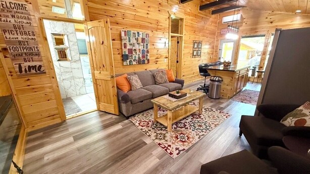 Un intérieur en bois avec un canapé, une table basse et un tapis.