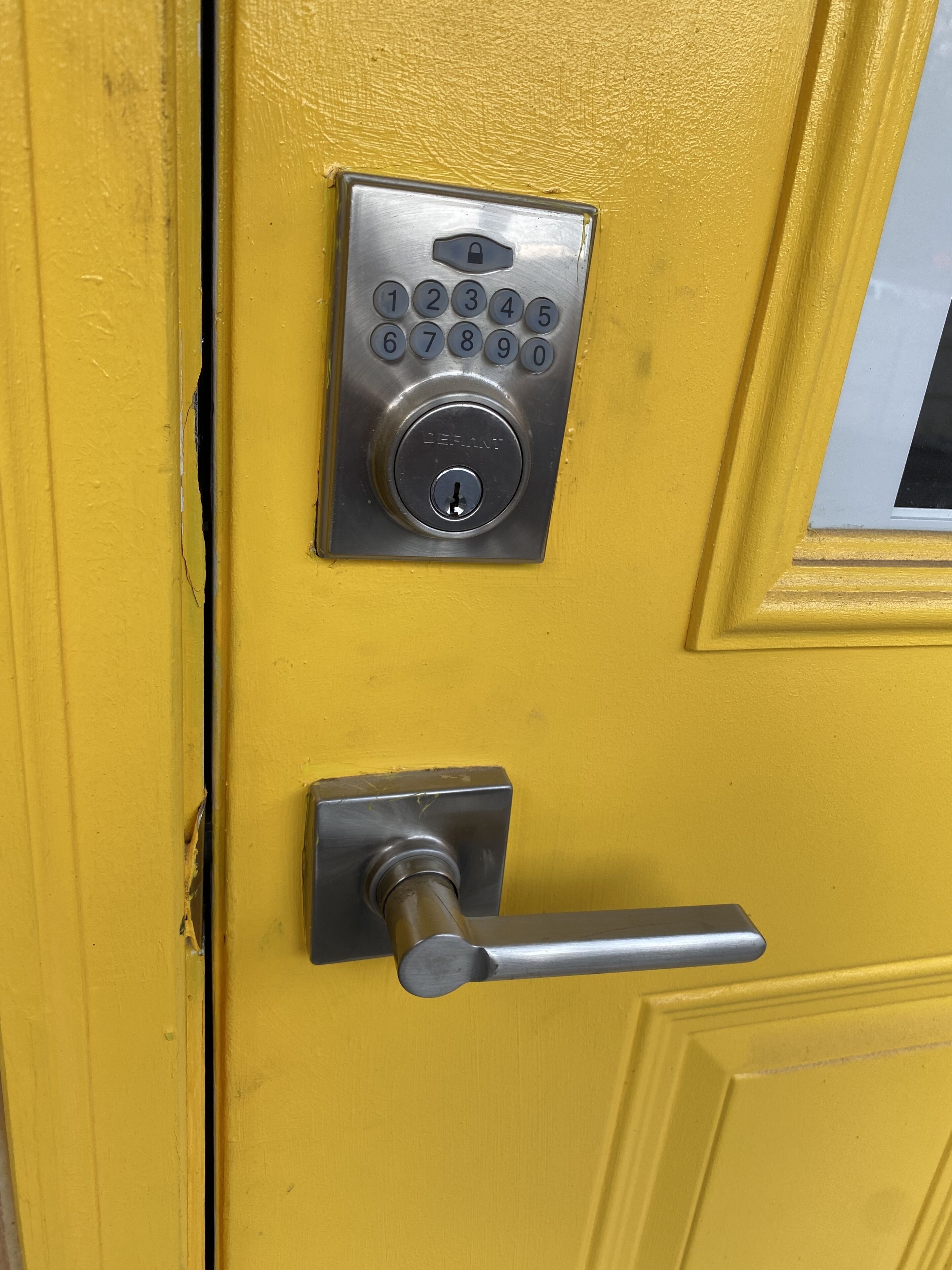 A yellow door with a numeric keypad lock and a keyhole.