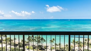 A beach view with clear blue water, palm trees, and a distant shoreline. - Oceanfront Views | Aston Waikiki Beach Tower 2BOF1 – Pool, Hot Tub & Spa (Honolulu)