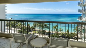 Ein Balkon mit Korbmöbeln und Blick auf das Meer und den Strand.