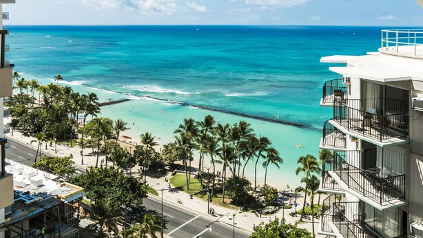 A beachfront hotel with balconies overlooking the ocean, a sandy beach, and palm trees. - Ocean View Condo | Aston Waikiki Beach Tower 2BOV2   – Pool, Hot Tub & Spa (Honolulu)