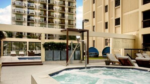 A rooftop pool area with lounge chairs, a hot tub, and a view of a high-rise building. - Sweeping Ocean Views | Aston Waikiki Beach Tower 2BOV3 – Pool, Hot Tub & Spa (Honolulu)