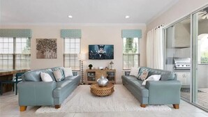 Ein Wohnzimmer mit zwei Sofas, einem Couchtisch und einem Fernseher.